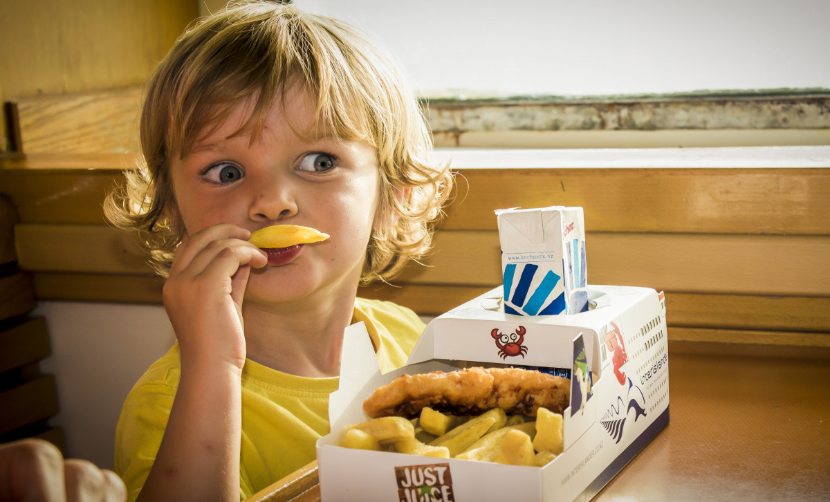 Child eating fish and chips kids meal on Interislander